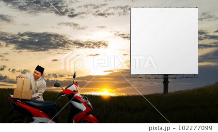Asian Muslim man tying box on motorcycle prepare for mudik 102277099