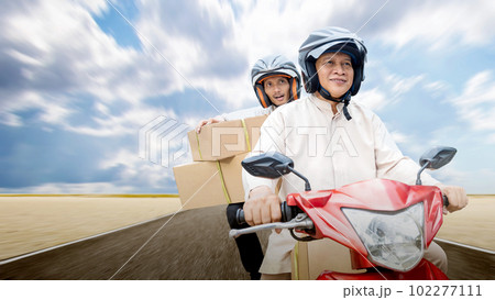 Asian Muslim family carrying a box on a motorcycle going mudik 102277111