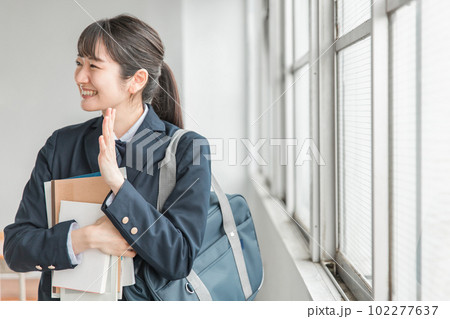 学校の教室で友達に手を振るアジア人の女子高生 学校の教室で友達に手を振るアジア人の女子高生 102277637