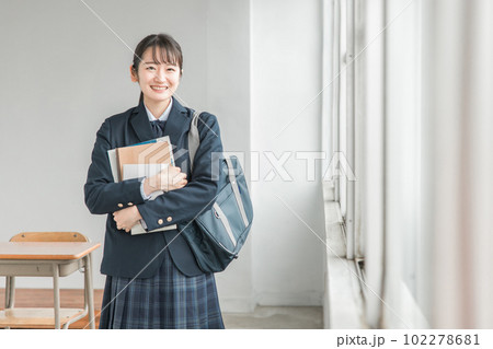 教室にいる教科書・参考書を持つ制服姿の女子高生 教室にいる教科書・参考書を持つ制服姿の女子高生 102278681
