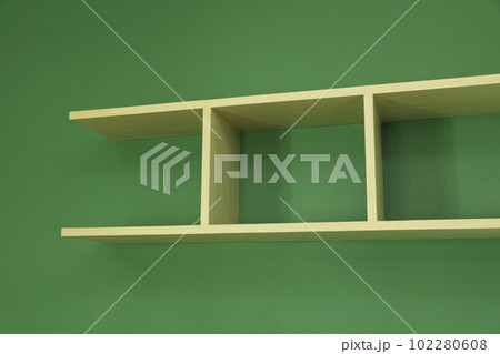 Wooden shelf installed on green wall Wooden shelf installed on green wall 102280608