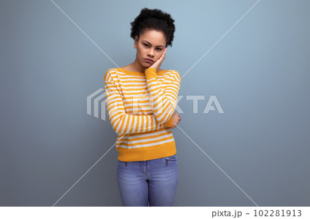 tired latin young woman with afro hair in yellow sweater tired latin young woman with afro hair in yellow sweater 102281913