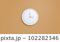 Clock on wall. White wall clock isolated on brown background.  102282346