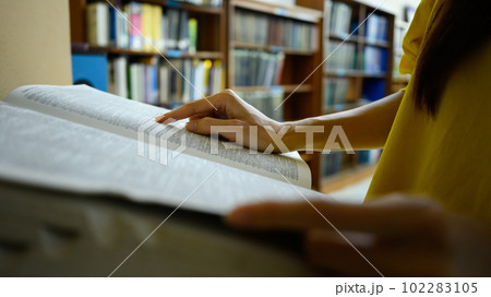 Peaceful woman reading interesting book in library. People, knowledge and education concept Peaceful woman reading interesting book in library. People, knowledge and education concept 102283105