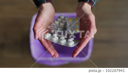 Close up woman hand throws medicine pills into the trash. The concept of the healthcare industry. 102287941