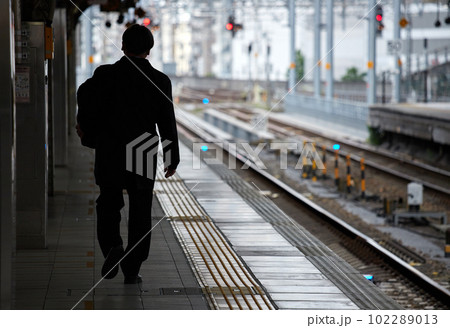 駅のホームで歩く一人のサラリーマンの後姿 駅のホームで歩く一人のサラリーマンの後姿 102289013