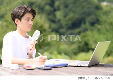 屋外で扇風機を使いながら勉強中の学生 屋外で扇風機を使いながら勉強中の学生 102289800