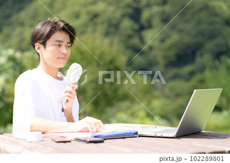 屋外で扇風機を使いながら勉強中の学生 屋外で扇風機を使いながら勉強中の学生 102289801