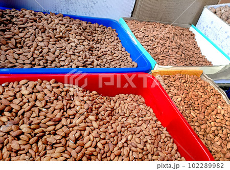 Peeled almonds are stired in a basket in a street shop 102289982