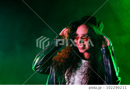 Pretty woman in green neon light. Smoky background, night party, disco club. 102290211
