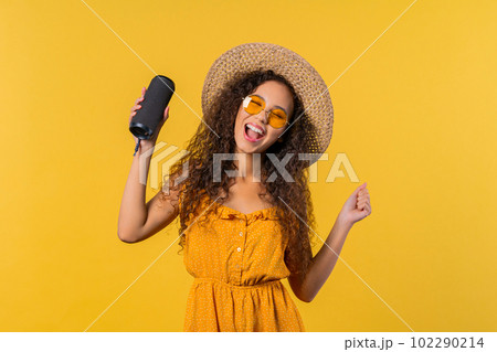 Summer woman dancing, enjoying on yellow background. She moves to music rhythm 102290214