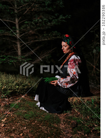 Witch woman collects herbs, ferns at night in Carpathian mountains forest. Witch woman collects herbs, ferns at night in Carpathian mountains forest. 102290386