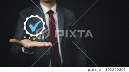 Quality assurance of business services, Businessman Hand shows the sign of the top service Quality assurance in Black background , Guarantee, Standards, ISO certification and standardization concept. 102290801