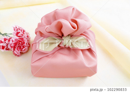 ピンクの風呂敷でラッピングしたプレゼントと花 ピンクの風呂敷でラッピングしたプレゼントと花 102290833