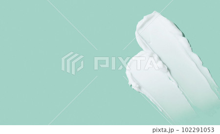 Beauty skincare cream texture swipe swatch. White beauty cream smear smudge isolated on green background Beauty skincare cream texture swipe swatch. White beauty cream smear smudge isolated on green background 102291053