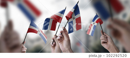 A group of people holding small flags of the Dominicana in their hands A group of people holding small flags of the Dominicana in their hands 102292520
