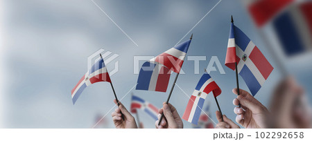 A group of people holding small flags of the Dominicana in their hands A group of people holding small flags of the Dominicana in their hands 102292658