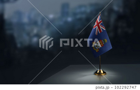 Small flags of the Cayman Islands on an abstract blurry background 102292747
