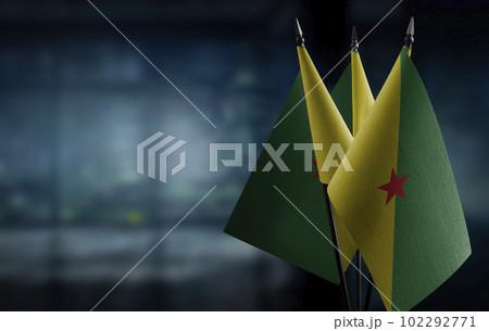 Small flags of the French Guiana on an abstract blurry background 102292771