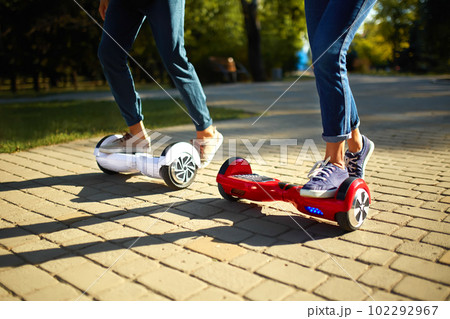 Young man and woman riding on the Hoverboard in the park. content technologies. a new movement. 102292967