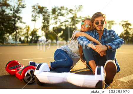 Young man and woman riding on the Hoverboard in the park. content technologies. a new movement. 102292970