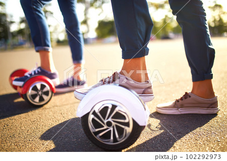 Young man and woman riding on the Hoverboard in the park. content technologies. a new movement. 102292973