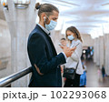 man and a woman in protective masks waiting for a train in the subway. 102293068