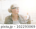 close up. serious business woman looking through office window 102293069