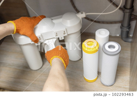Plumber installs or change water filter. Replacement aqua filter Plumber installs or change water filter. Replacement aqua filter 102293463