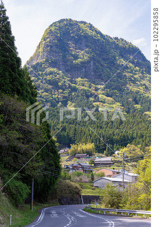 曽爾巾着山公園から見た風景　逆光にかすむ鎧岳と手前を走る県道 102295858