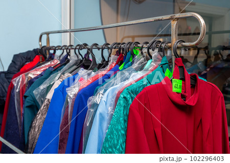Hangers with men suits and women clothes for the deceased in a funeral goods store. Hangers with men suits and women clothes for the deceased in a funeral goods store. 102296403