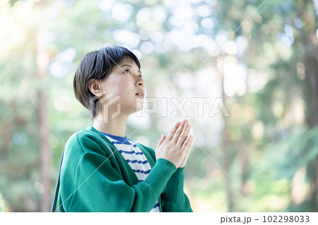 お参りをする女性　願掛けをする女性　合掌　お祈り　参拝　パワースポット巡り　神社 102298033
