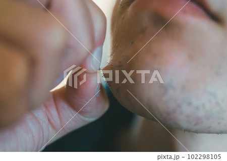 あごヒゲを指で抜く男性 102298105