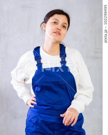 Positive young woman cleaning service worker in blue uniform Positive young woman cleaning service worker in blue uniform 102299495