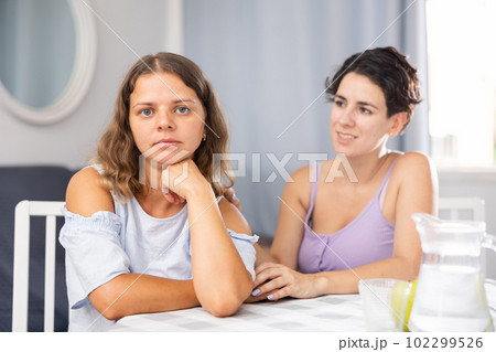 Beautiful girl with dark hair keep arms folded, do not talk to her friend 102299526
