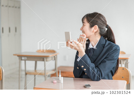 放課後に学校の教室で友達とおしゃべりしながらメイクをする笑顔の女子高生 放課後に学校の教室で友達とおしゃべりしながらメイクをする笑顔の女子高生 102301524