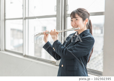 教室でフルートを吹く吹奏楽部のアジア人女子高生 102302395