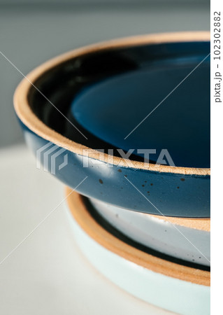 A large stack of ceramic cups in pastel colors. A large stack of ceramic cups in pastel colors. 102302882