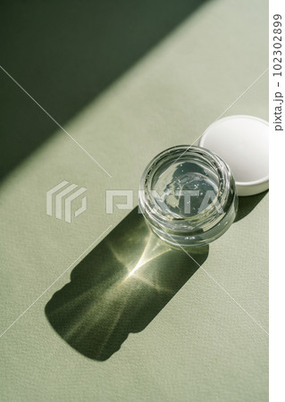 Transparent gel in a jar on a green background. Transparent gel in a jar on a green background. 102302899