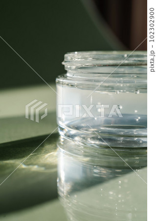 Transparent gel in a jar on a green background. 102302900
