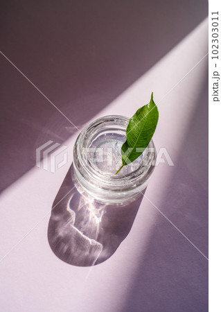 Transparent gel in a jar on a lilac background. Transparent gel in a jar on a lilac background. 102303011
