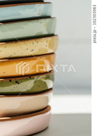 A large stack of ceramic cups in pastel colors. A large stack of ceramic cups in pastel colors. 102303063