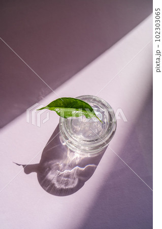 Transparent gel in a jar on a lilac background. Transparent gel in a jar on a lilac background. 102303065