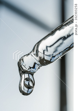 Cosmetic pipette with a drop on a heavenly background. Cosmetic pipette with a drop on a heavenly background. 102303258