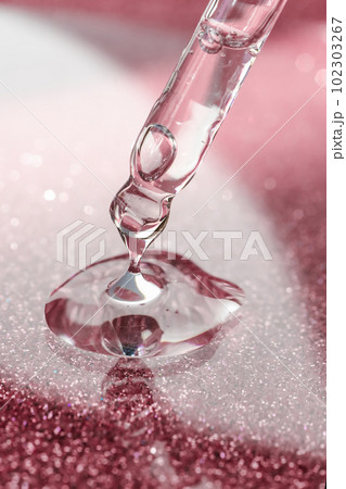 Cosmetic pipette with a pink on dark background. Cosmetic pipette with a pink on dark background. 102303267