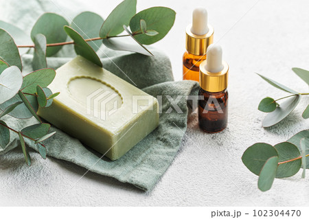 Soap, eucalyptus, aroma essential oil, spa objects on a concrete background. Soap, eucalyptus, aroma essential oil, spa objects on a concrete background. 102304470