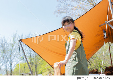 キャンプ場で薪割りをする女の子 キャンプ場で薪割りをする女の子 102307125
