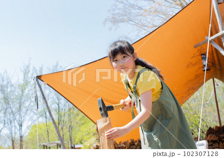 キャンプ場で薪割りをする女の子 キャンプ場で薪割りをする女の子 102307128