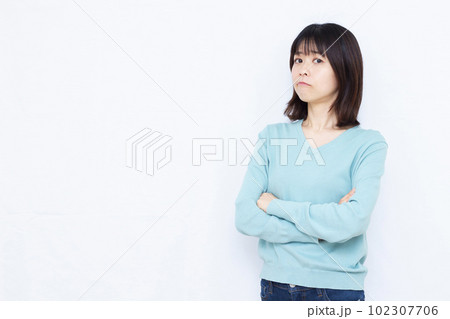 白い背景の前で腕を組み怒っている30代の女性 白い背景の前で腕を組み怒っている30代の女性 102307706