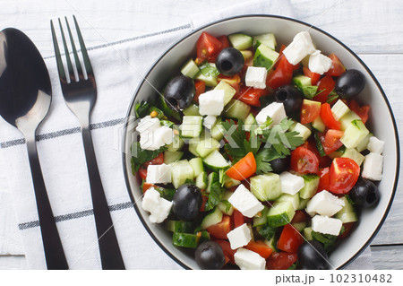 Turkish Shepherds Salad  is a delicious dish made with fresh vegetables like bell pepper, cucumber and tomato and cheese closeup in the bowl. Horizontal top view 102310482